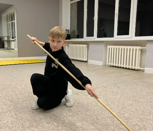 Упражнение с шестом в низкой стойке